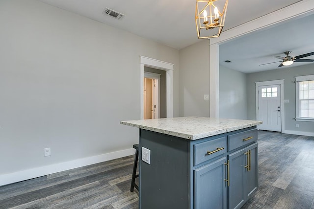 kitchen featuring a kitchen bar, dark hardwood / wood-style floors, hanging light fixtures, and a kitchen island