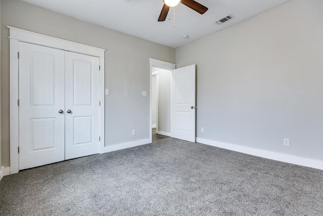 unfurnished bedroom featuring dark carpet, a closet, and ceiling fan