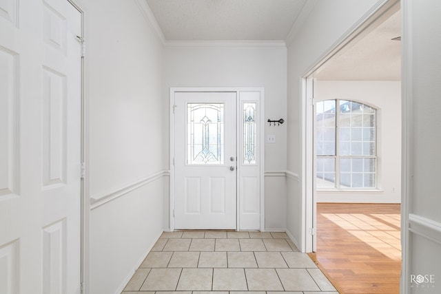 entrance foyer featuring light tile patterned flooring, crown molding, and a textured ceiling