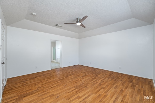 unfurnished room featuring vaulted ceiling, ceiling fan, light hardwood / wood-style floors, and a textured ceiling