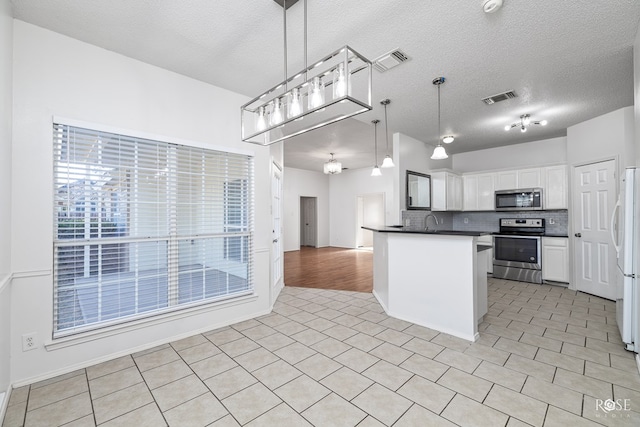 kitchen featuring tasteful backsplash, decorative light fixtures, a textured ceiling, appliances with stainless steel finishes, and white cabinets