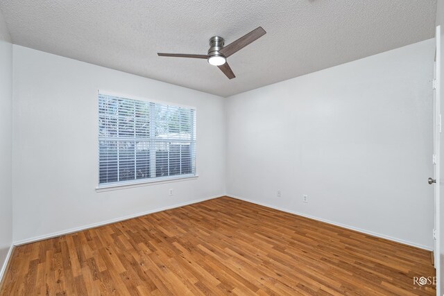 empty room with ceiling fan, hardwood / wood-style flooring, and a textured ceiling