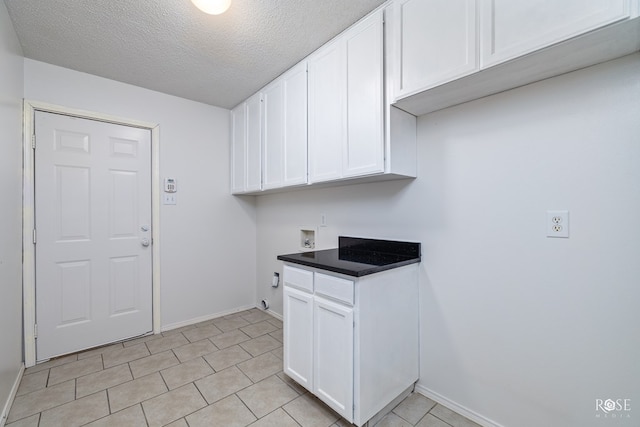 kitchen with white cabinetry, a textured ceiling, and light tile patterned floors