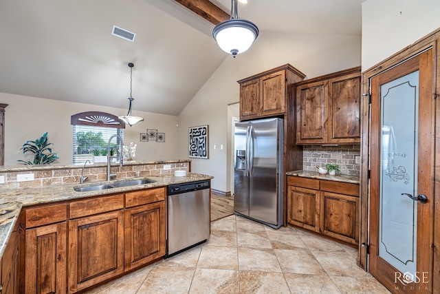 7738 Bison Trl, San Angelo, TX 76901 - kitchen featuring appliances with stainless steel finishes, a sink, lofted ceiling, backsplash, and brown cabinets