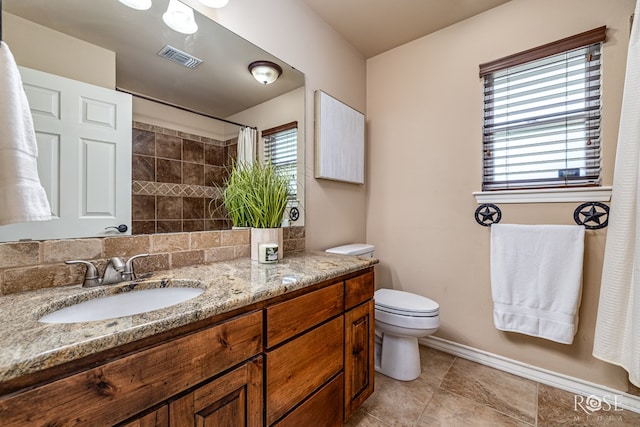 7738 Bison Trl, San Angelo, TX 76901 - bathroom featuring toilet, vanity, curtained shower, backsplash, and baseboards