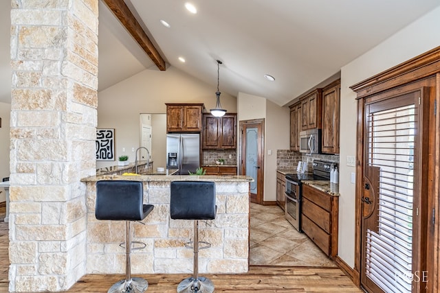 7738 Bison Trl, San Angelo, TX 76901 - kitchen featuring stainless steel appliances, a peninsula, tasteful backsplash, a breakfast bar area, and light stone countertops