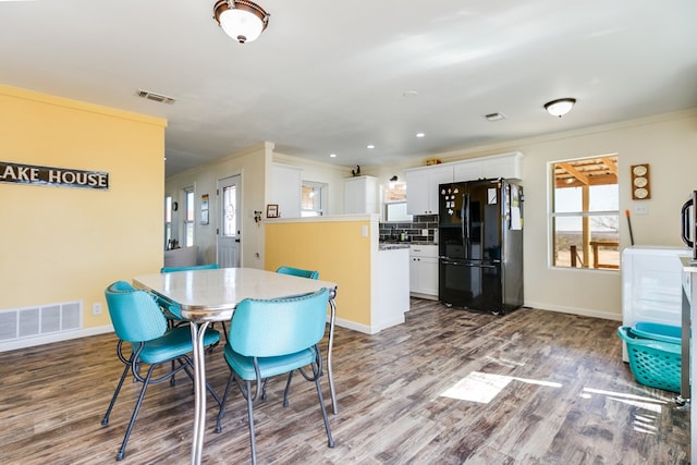 dining room with visible vents, wood finished floors, and ornamental molding