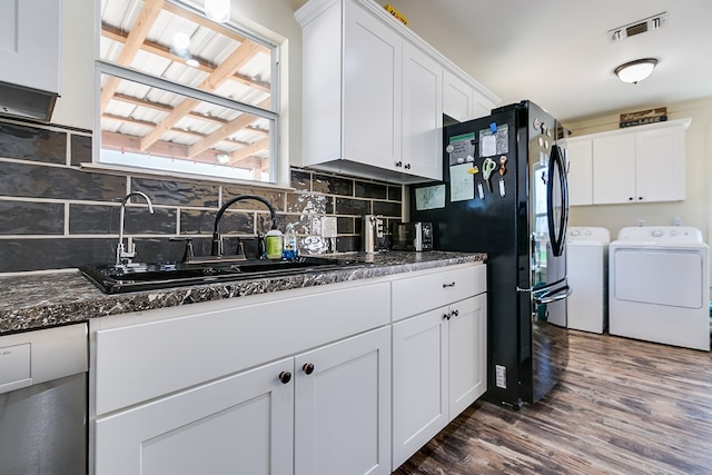 kitchen featuring visible vents, independent washer and dryer, a sink, freestanding refrigerator, and white cabinetry