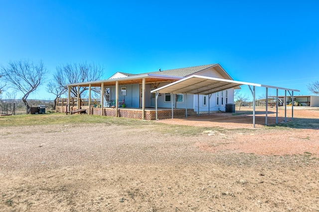 farmhouse inspired home featuring central AC unit and a detached carport