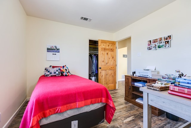 bedroom featuring visible vents, baseboards, and wood finished floors