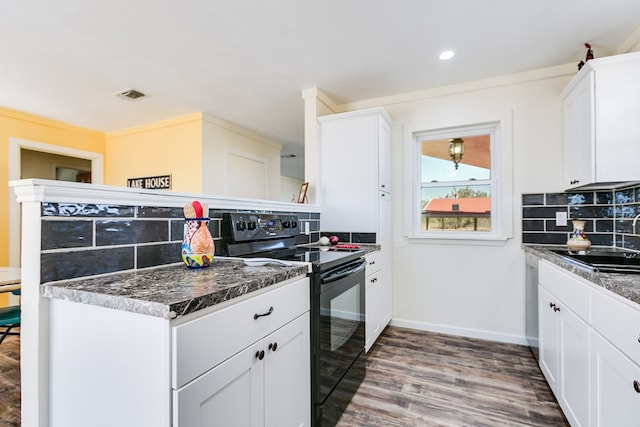 kitchen featuring visible vents, black electric range oven, a sink, wood finished floors, and decorative backsplash