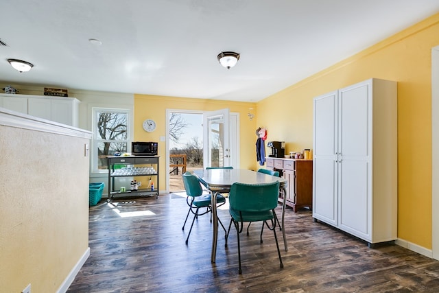 dining area featuring dark wood-style floors and baseboards