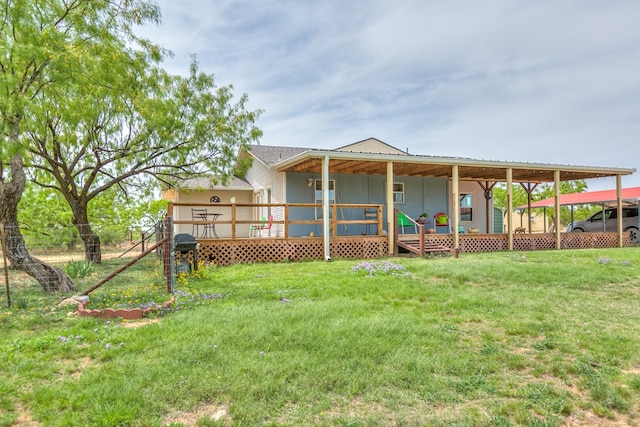 back of property with a wooden deck, a carport, and a yard