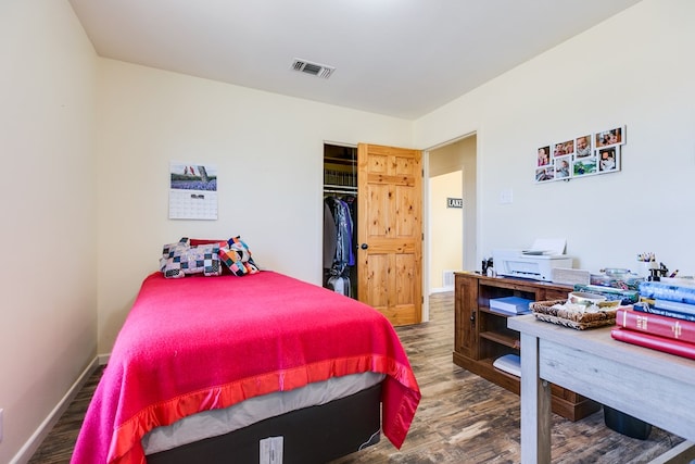 bedroom featuring wood finished floors, visible vents, and baseboards