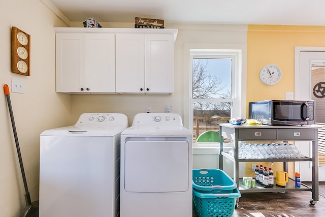 laundry room with washer and dryer, cabinet space, and wood finished floors