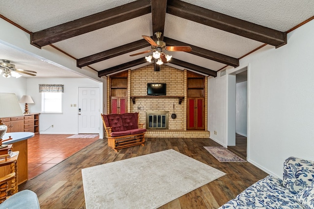 8881 Rust Rd, San Angelo, TX 76905 - living room with ceiling fan, a textured ceiling, baseboards, wood finished floors, and a fireplace