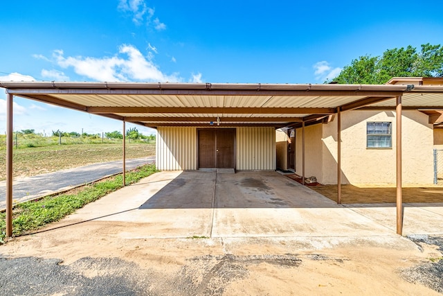 8881 Rust Rd, San Angelo, TX 76905 - view of front facade featuring stucco siding, driveway, and an attached carport