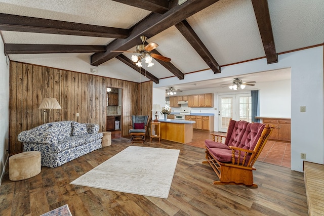 8881 Rust Rd, San Angelo, TX 76905 - living area with ceiling fan, wood walls, hardwood / wood-style floors, and a textured ceiling