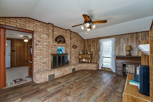 8881 Rust Rd, San Angelo, TX 76905 - unfurnished living room with lofted ceiling, ceiling fan, a brick fireplace, a textured ceiling, and wood finished floors