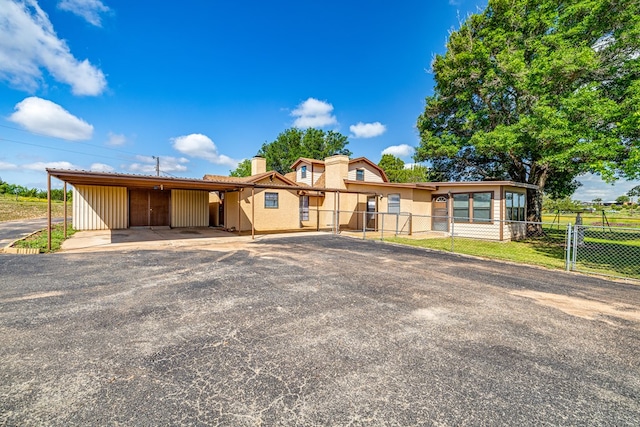 8881 Rust Rd, San Angelo, TX 76905 - view of front facade with fence, a chimney, an attached carport, driveway, and a gate