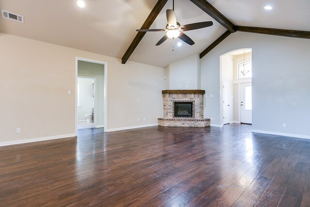 unfurnished living room with dark wood finished floors, visible vents, a ceiling fan, beamed ceiling, and baseboards