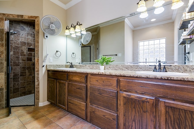 bathroom with a shower stall, double vanity, a sink, and crown molding