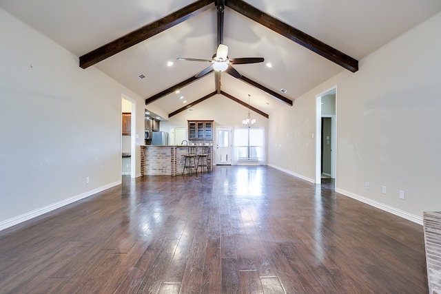 unfurnished living room with ceiling fan with notable chandelier, beamed ceiling, dark wood finished floors, and baseboards