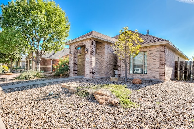 view of front of property with fence and brick siding