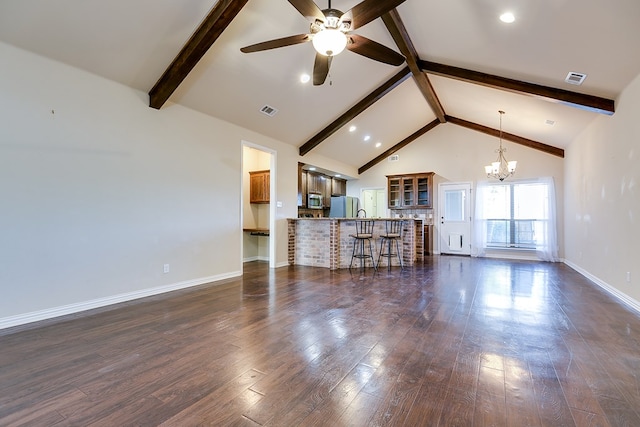 unfurnished living room with baseboards, visible vents, dark wood-type flooring, beamed ceiling, and high vaulted ceiling