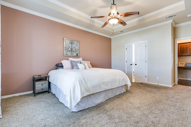 bedroom featuring carpet flooring, visible vents, baseboards, ornamental molding, and a raised ceiling