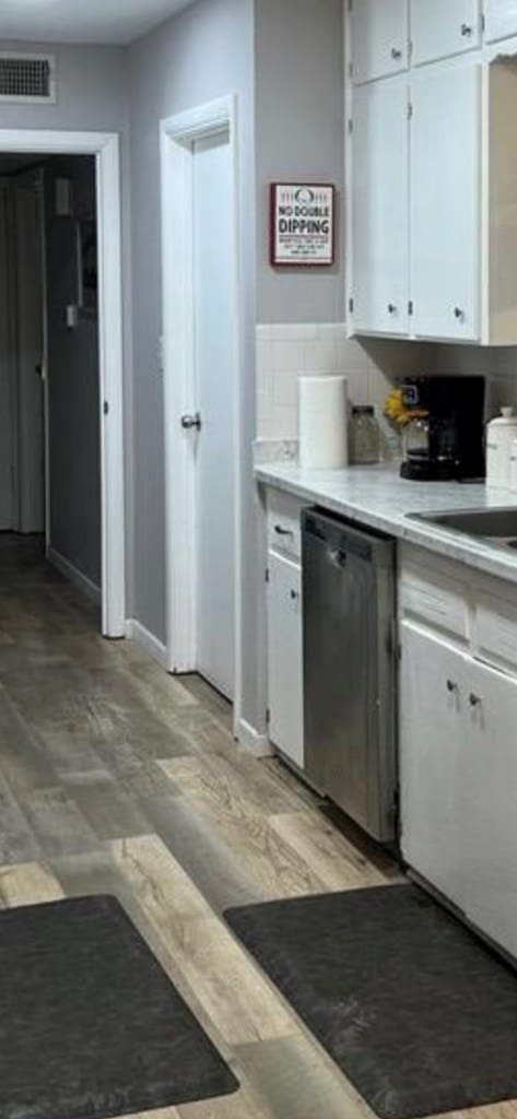 2525 Tcu Ave, San Angelo, TX 76904 - kitchen with stainless steel dishwasher, white cabinets, and light countertops
