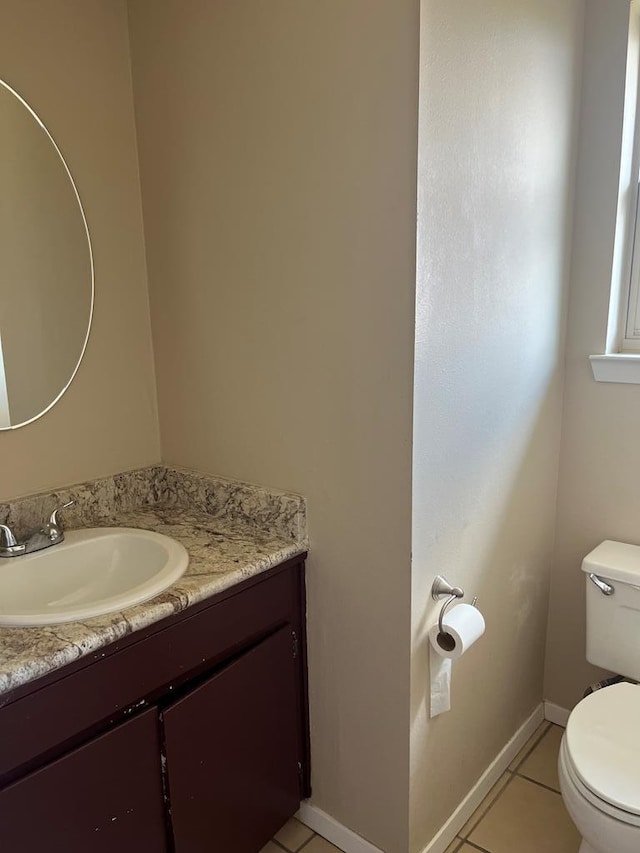 bathroom featuring vanity, tile patterned floors, and toilet