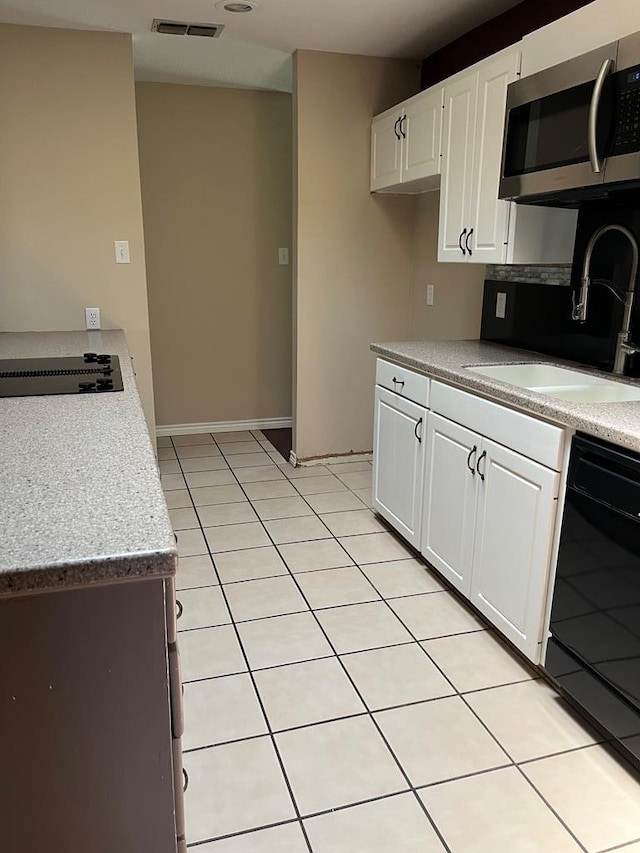 kitchen featuring white cabinetry, light tile patterned floors, sink, and black appliances