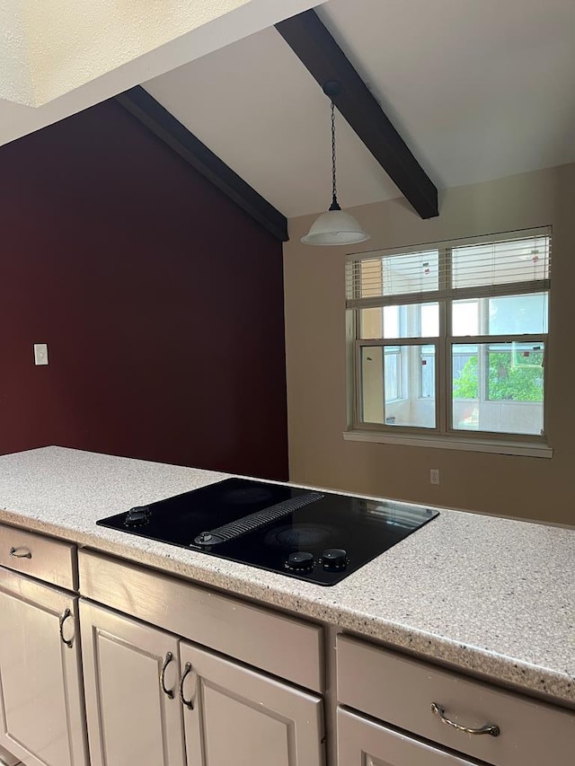 kitchen featuring white cabinetry, light stone counters, black electric stovetop, decorative light fixtures, and beamed ceiling