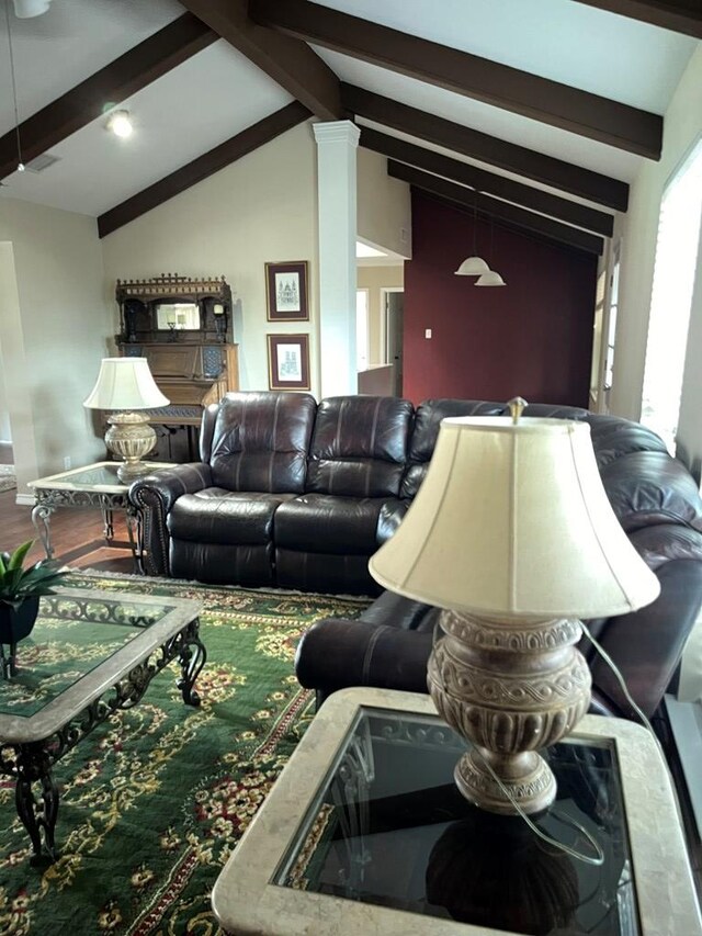 living room featuring hardwood / wood-style flooring, ornate columns, and vaulted ceiling with beams