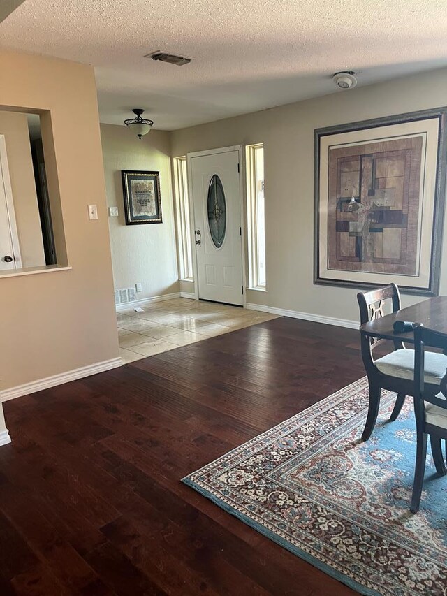 entrance foyer with light hardwood / wood-style floors and a textured ceiling