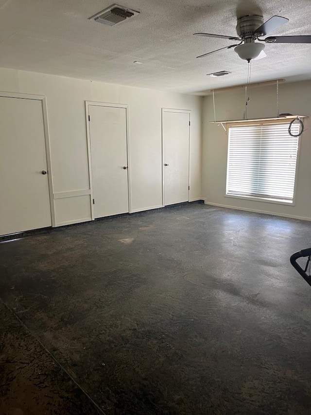 interior space with ceiling fan and a textured ceiling