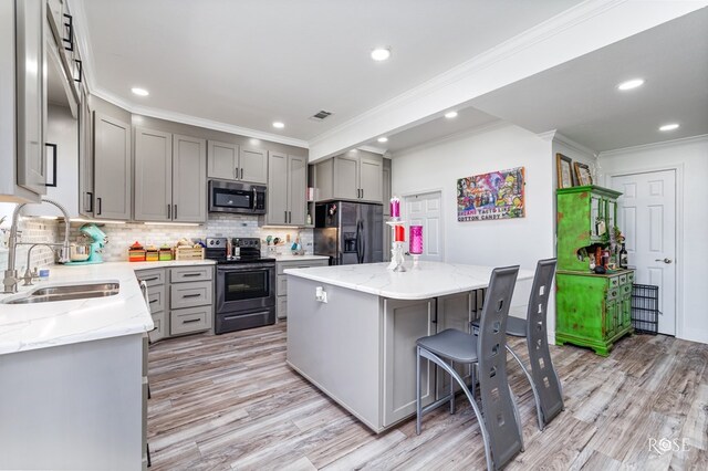 1920 Shady Point Circle Dr, San Angelo, TX 76904 - kitchen with black appliances, a sink, gray cabinets, a center island, and crown molding