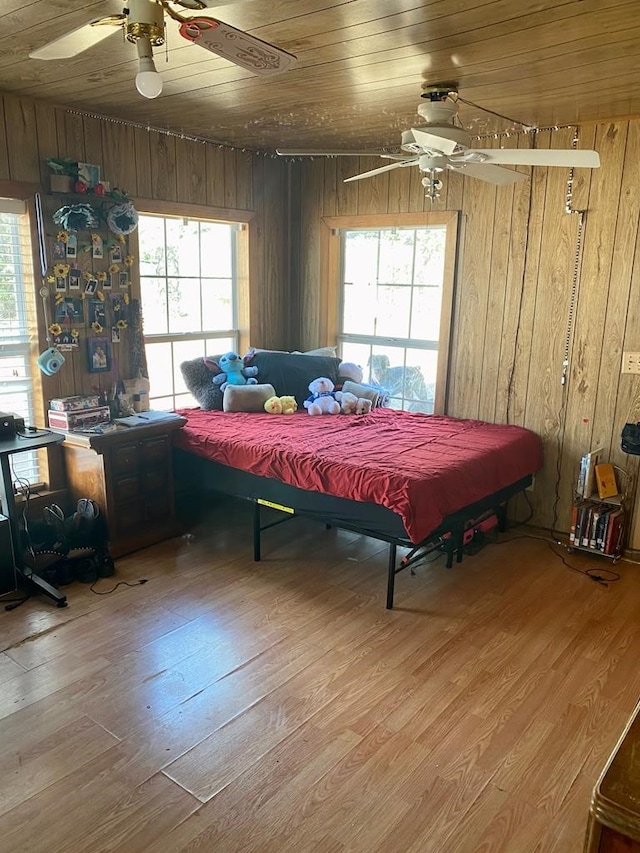 bedroom with multiple windows, wooden ceiling, and wood walls