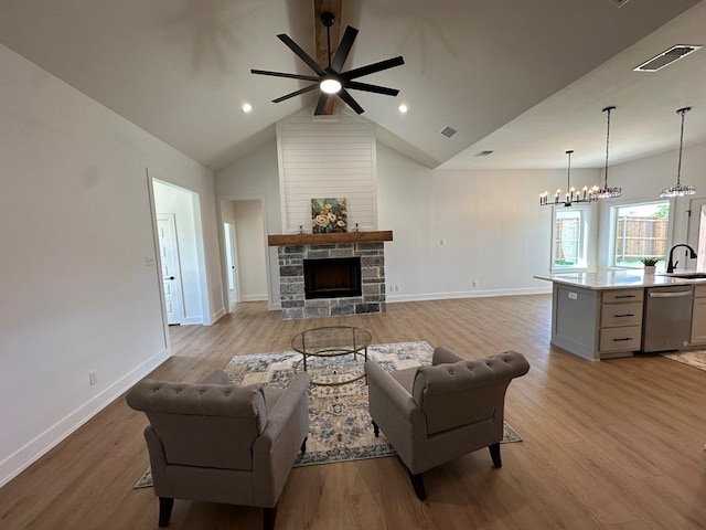3615 Clearview Dr, San Angelo, TX 76904 - living area with a ceiling fan, a fireplace, light wood-style floors, a chandelier, and lofted ceiling