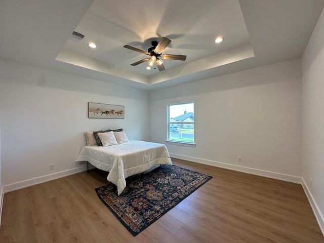 3615 Clearview Dr, San Angelo, TX 76904 - bedroom featuring wood finished floors, a tray ceiling, recessed lighting, and a ceiling fan