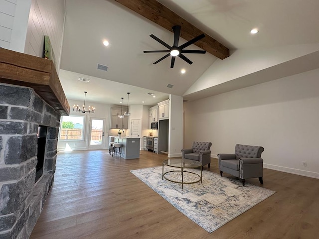 3615 Clearview Dr, San Angelo, TX 76904 - living area featuring ceiling fan, beam ceiling, a fireplace, a chandelier, and dark wood-type flooring