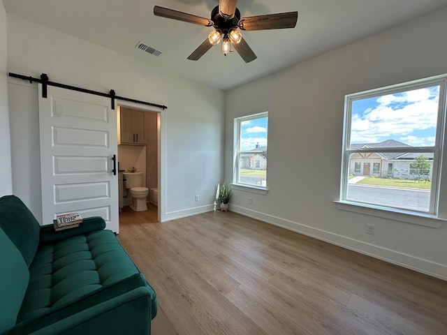 3615 Clearview Dr, San Angelo, TX 76904 - living room featuring a barn door, light wood-type flooring, and a ceiling fan