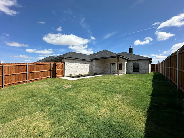 3615 Clearview Dr, San Angelo, TX 76904 - back of house with a fenced backyard, a chimney, and brick siding
