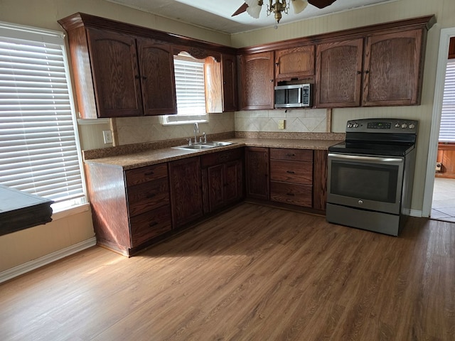 42 W 26th St, San Angelo, TX 76903 - kitchen with appliances with stainless steel finishes, a sink, wood finished floors, and tasteful backsplash