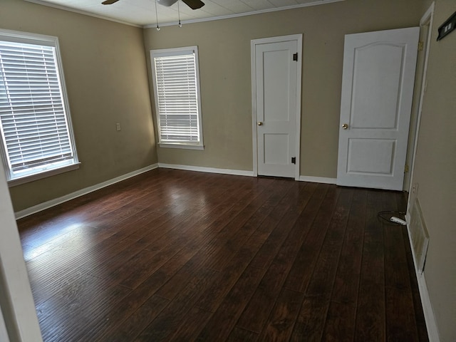 42 W 26th St, San Angelo, TX 76903 - unfurnished bedroom featuring ornamental molding, dark wood-type flooring, baseboards, and multiple windows