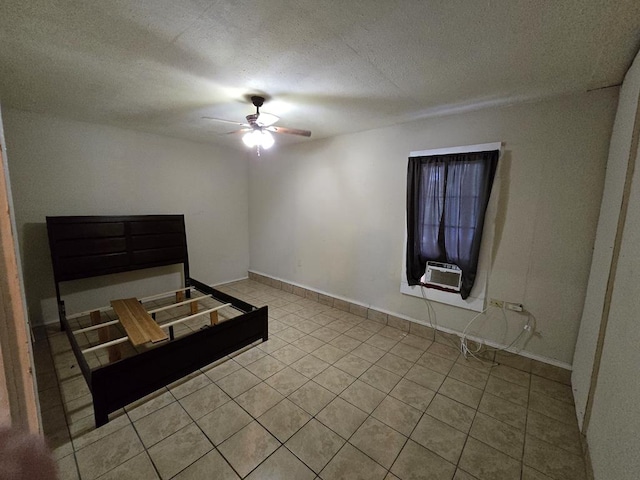 42 W 26th St, San Angelo, TX 76903 - unfurnished bedroom with cooling unit, ceiling fan, baseboards, tile patterned floors, and a textured ceiling