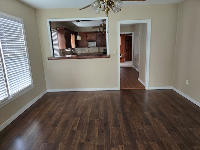 42 W 26th St, San Angelo, TX 76903 - unfurnished living room with ceiling fan, dark wood finished floors, baseboards, and a sink