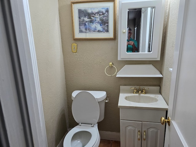 42 W 26th St, San Angelo, TX 76903 - half bath featuring vanity, toilet, a textured wall, and tile patterned flooring
