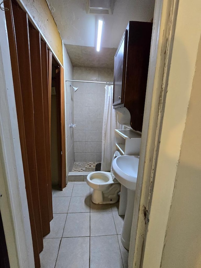 42 W 26th St, San Angelo, TX 76903 - bathroom featuring tile patterned floors, toilet, and a stall shower